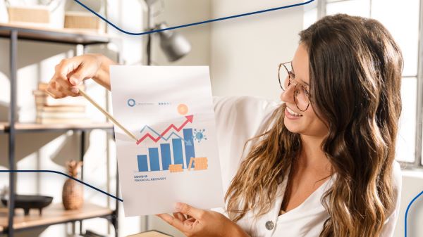 Una agente explicando gráficas de retorno de inversión que se obtiene al adquirir mejores opciones de departamentos en venta.